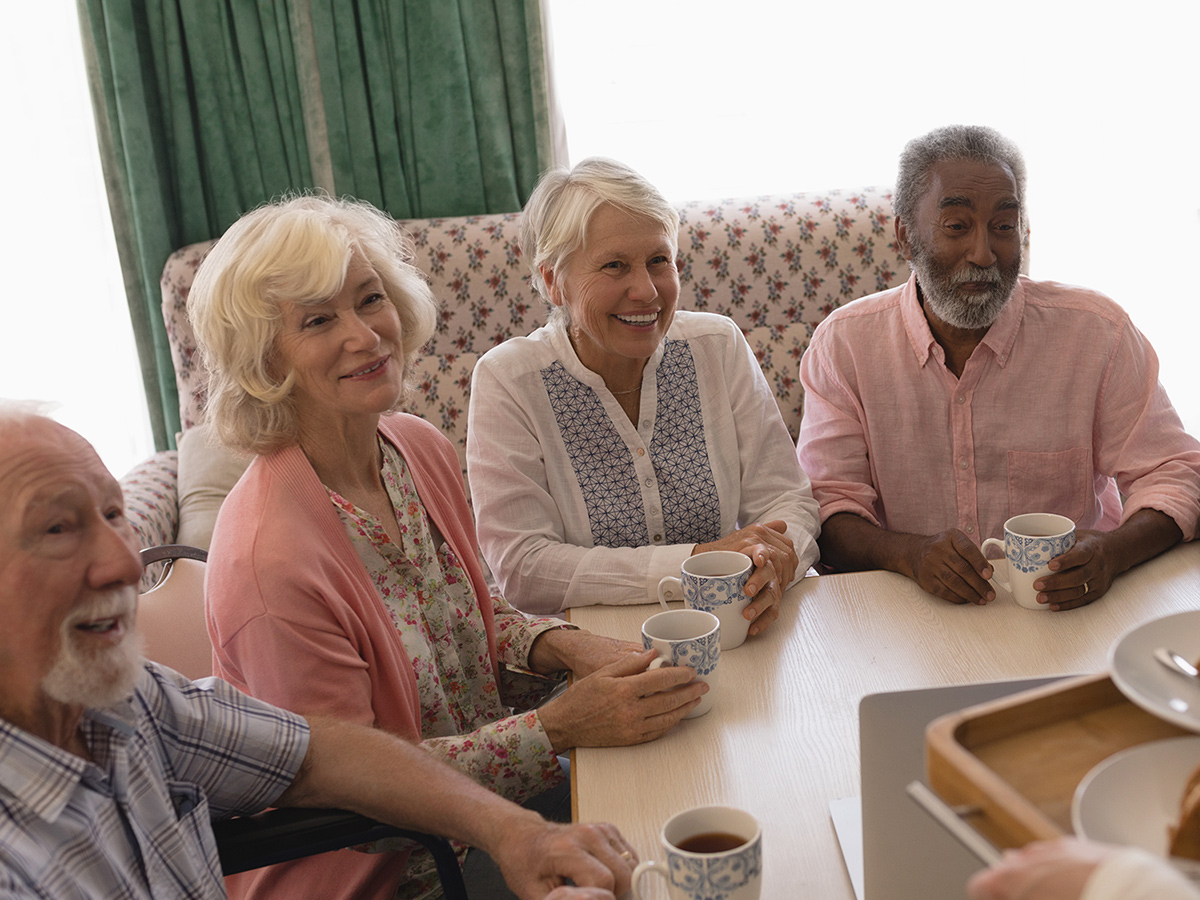 A group of seniors enjoying their breakfast at an assisted living facility.